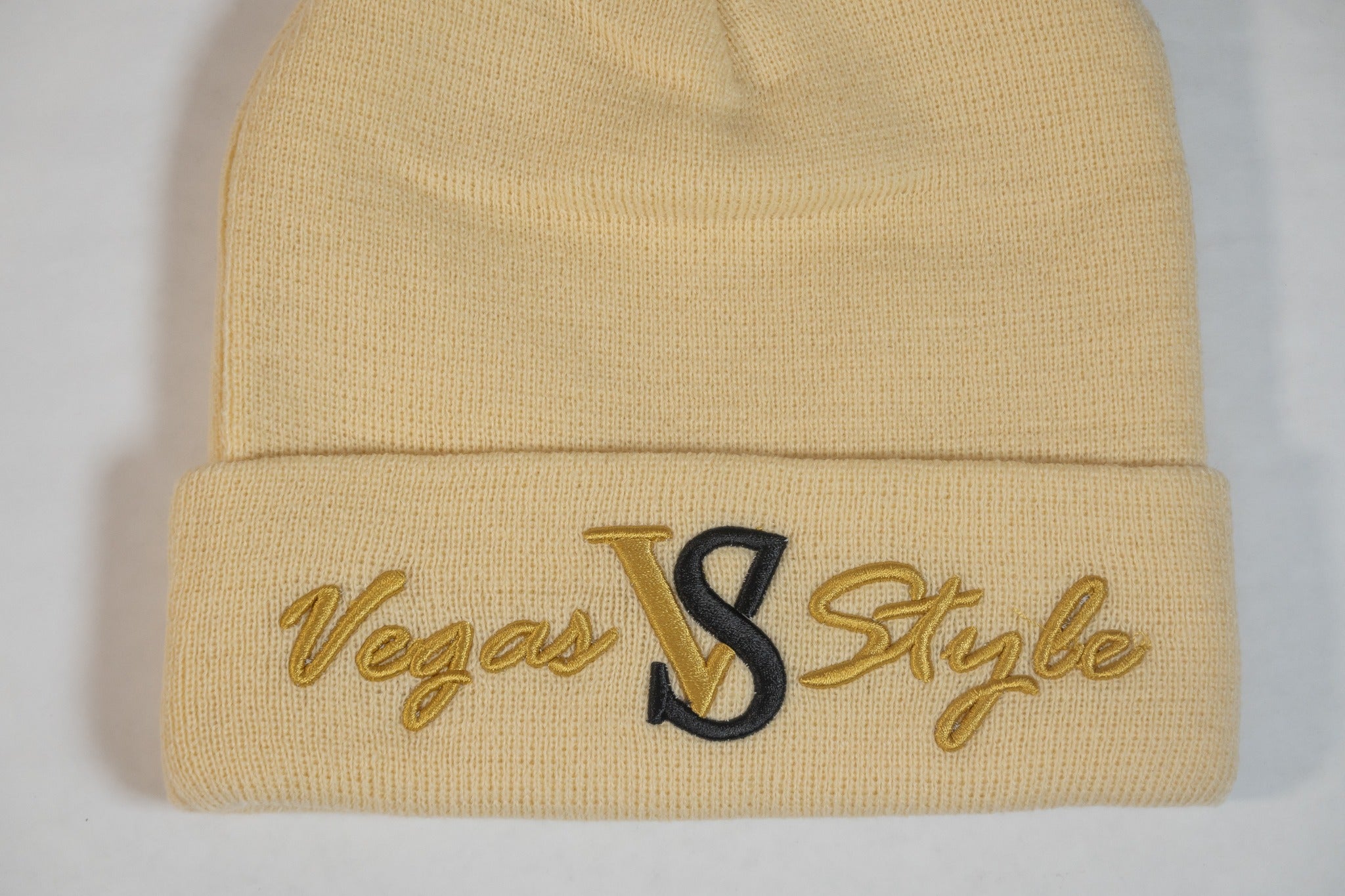 Cream cuffed knit beanie with gold and black embroidered Vegas Style logo