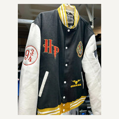 Angled front detail of black cream and gold Harry Potter-themed varsity jacket