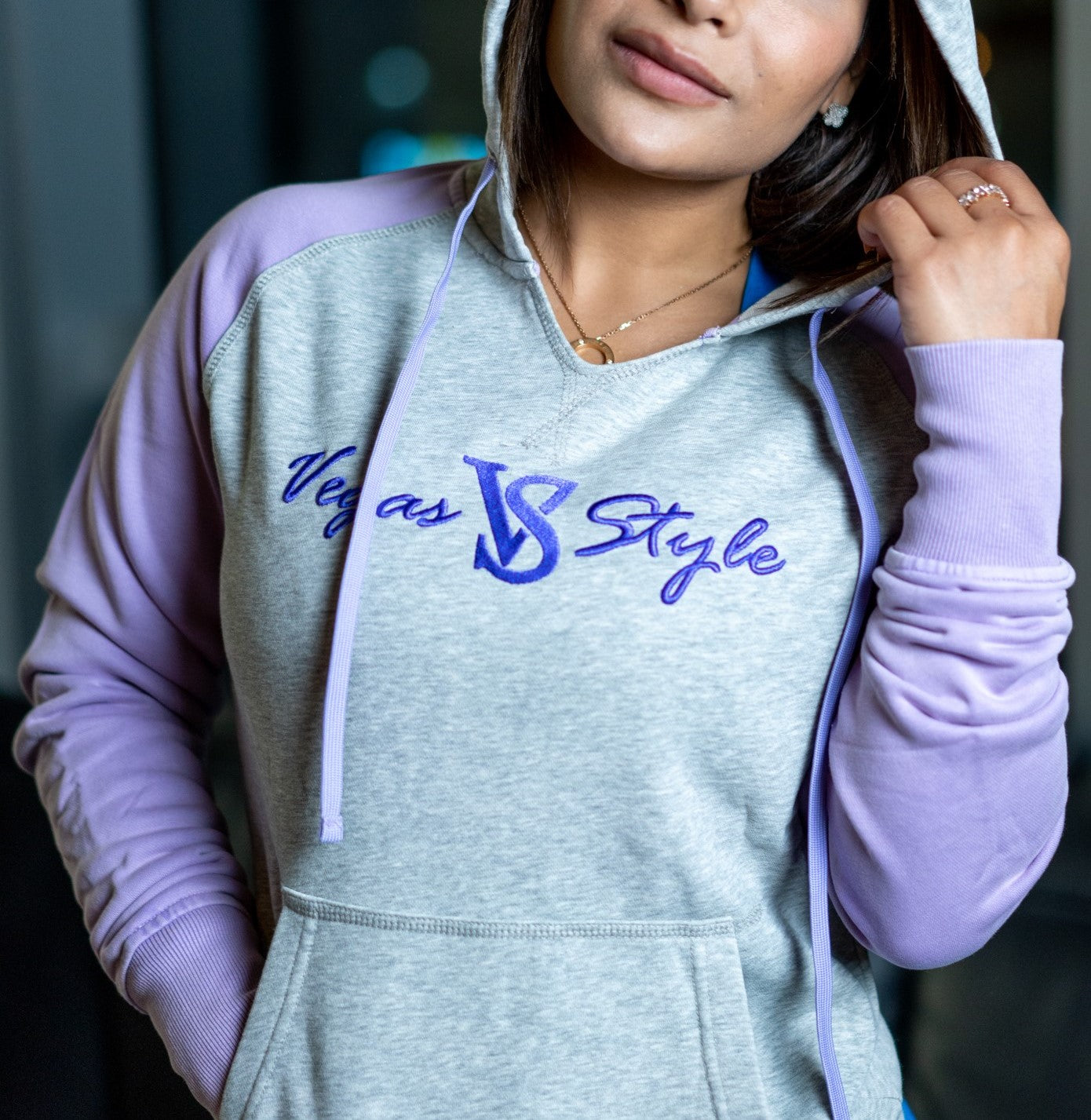 Woman wearing a gray and lavender Vegas Style embroidered pullover hoodie
